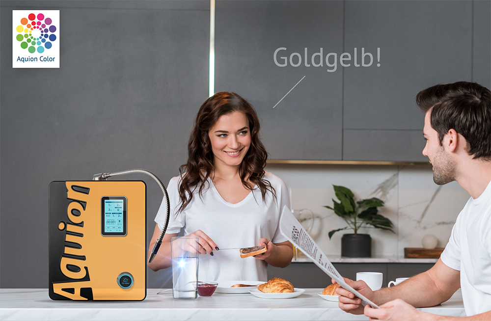 Paar in Küche vor goldfarbenem WasserIonisierer