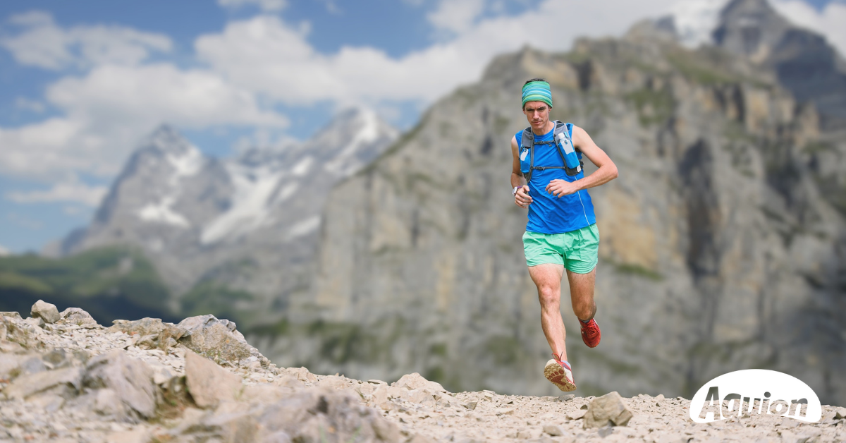 Leistungssportler läuft durch die Berge. Sportlerwasser von Aquion ist das Thema