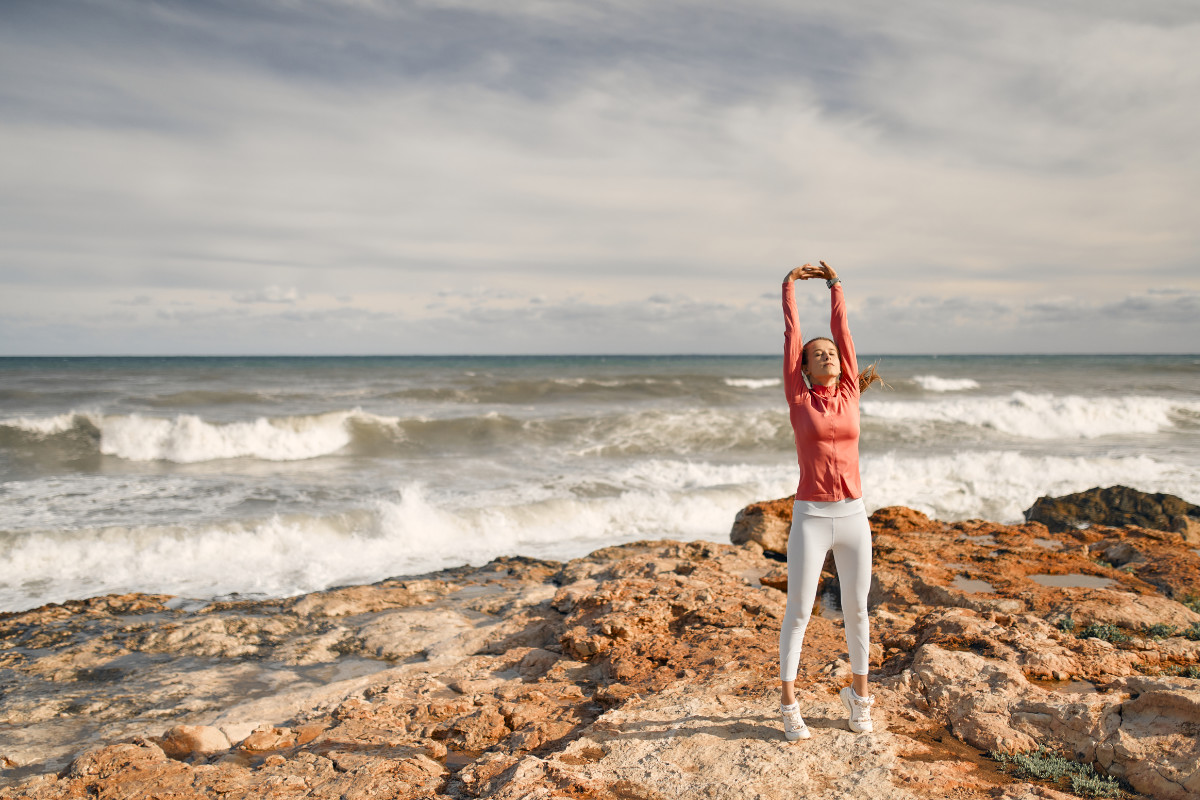 Frau macht Yoga am Meer