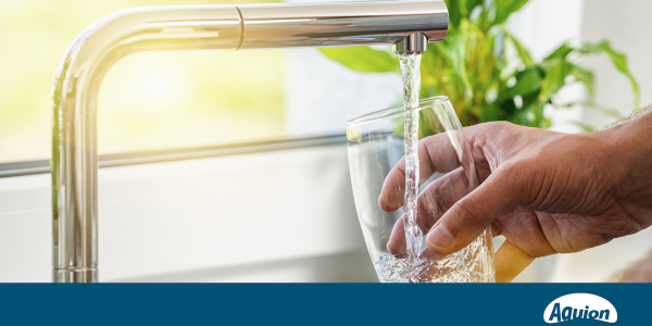 Ein Glas wird unter einen Wasserhahn gehalten und mit Leitungswasser gefüllt