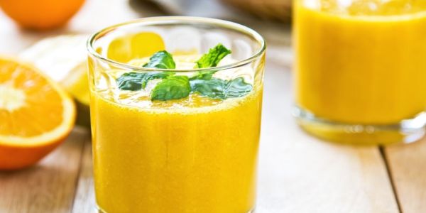 2 Gläser mit Smoothies und Orangen